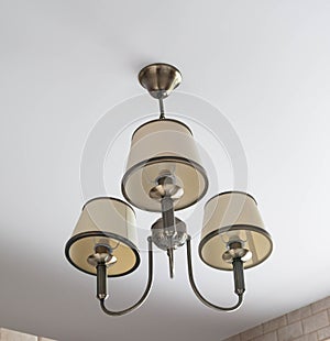 Chandelier on the ceiling. Retro ceiling lamp. Beautiful chandelier hanging on the ceiling in a bright room