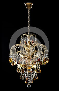 Chandelier for interior of the living room. chandelier decorated with crystals and amber isolated on black background.