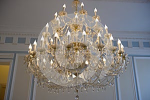 The chandelier is large crystal with lamps and candles.