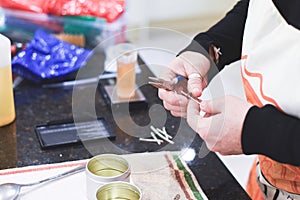 A Chandler or candle maker adds a wick to scented hand made candles