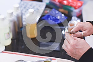 A Chandler or candle maker adds a wick to scented hand made candles