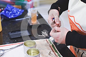 A Chandler or candle maker adds a wick to scented hand made candles