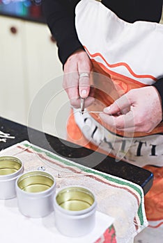 A Chandler or candle maker adds a wick to scented hand made candles