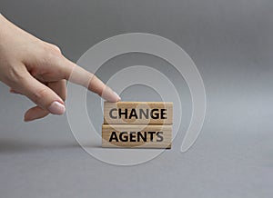 Change agents symbol. Concept word Change agents on wooden blocks. Beautiful grey background. Businessman hand. Business and