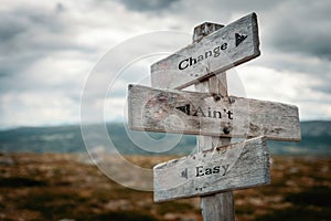 Change aint easy text on wooden rustic signpost outdoors in nature photo