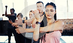 And change. a focused group of young people standing in a row and stretching before a workout session in a gym.