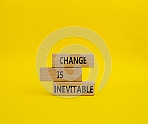 Change is Inevitable symbol. Wooden blocks with words Change is Inevitable. Beautiful yellow background. Business and Change is