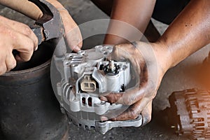 Change new car alternator with hand in the garage or auto repair service center, as background automotive concept. Dark tone