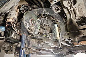 Change and repair clutch, drive axle. working underneath a lifted car. Professional mechanic work maintenance car