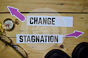 Change or Stagnation opposite direction signs with boots, eyeglasse and compass on wooden