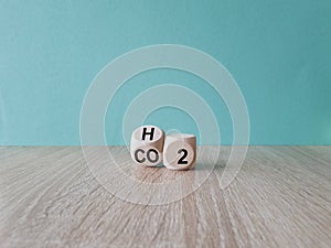 Change to fuel cell vehicles. Fliped cube, changed the expression CO2 to H2. Beautiful wooden table, blue background. Ecological