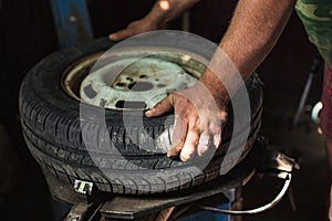 Change a Tyre, Car Mechanic is Changing a Tyre in a Garage