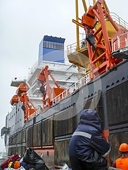 Change of watch. Workers are sitting on a boat. Workers sailed to the barge