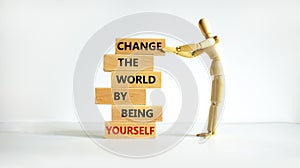 Change the world by being yourself symbol. Wooden blocks with words Change the world by being yourself. Businessman model.