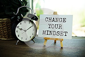 Change your mindset text message on paper card with wooden easel on wooden table background, inspiration motivation concept