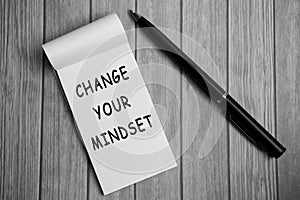 Change your mindset text on notepad and a pen on a wooden desk