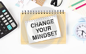 Change Your Mindset Text written on notebook page, red pencil on the right. Motivational