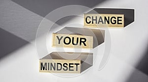 CHANGE YOUR MINDSET written on wooden blocks and white background. Motivation, positive wishes, business, finance
