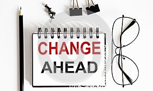 CHANGES AHEAD notepad writing on white background with pencil and glasses