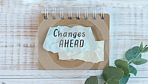 CHANGES AHEAD text, written on sticker with green eucalyptus branch