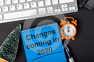 Changes coming in 2020. text on notebook at desk with little Christmas tree and clock. New year 2020