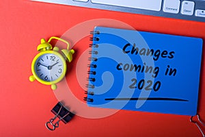 Changes coming in 2020. Text on notebook at red desk. New year 2020