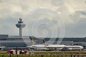 Airplanes Of Singapore Airlines At Changi International Airport With Air Traffic Control Tower.