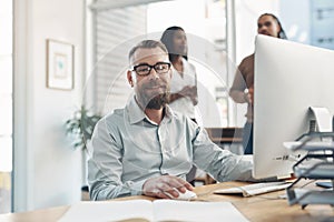 Changing the business world one project at a time. Cropped portrait of a handsome young businessman sitting and using a