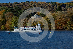 The changing colours of autumn trees & a Pleasure Cruiser. Windermere. Lake District, UK