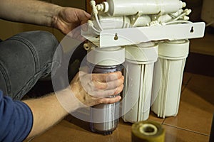 Changing filters in your home water purification system. The master prepared to replace the first filter 5 microns