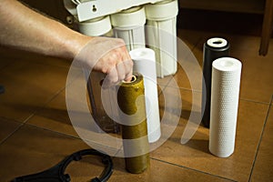 Changing filters in your home water purification system. The master prepared to replace the first filter 5 microns