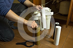 Changing filters in your home water purification system. The master prepared to replace the first filter 5 microns