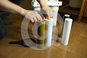 Changing filters in your home water purification system. The master prepared to replace the first filter 5 microns
