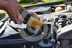 Changing the oil filter in the car. Hand inserting a new oil filter designed to remove contaminants from engine