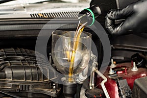 Changing replacement car oil with plastic bottle. DIY change engine motor oil. At home vehicle maintenance. Garage mechanic