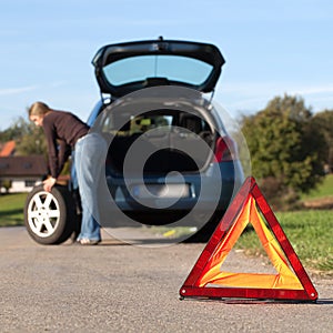 Changing the tire on a broken down car