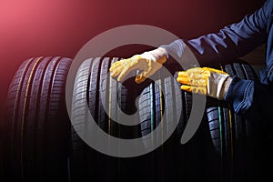 Changing tires background with service man hands with new wheels from storage.