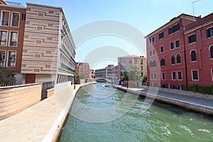 Channel with boat and modern buildings in district sestiere Santa Croce in Venice, Italy photo