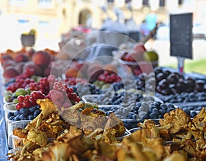 Chanterelles or girolle mushrooms and other fruit and vegetables for sale at local farmers market. Fresh organic produce