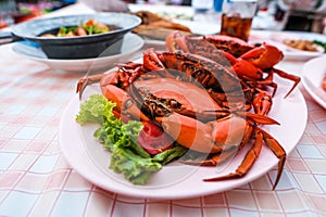 Many bright red steamed sea crabs Lined in a plate ready to serve for those who like to eat seafood. photo