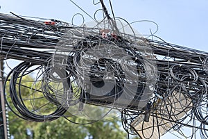 Chaos of cables and wires on an electric pole. Many electrical cable - wire and telephone line on electricity post, Thailand
