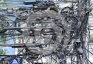 Chaos of cables and wires on an electric pole. Many electrical cable - wire and telephone line on electricity post. Wire and cable