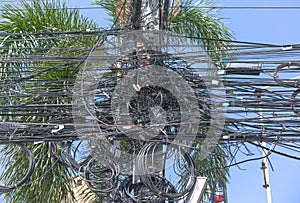 Chaos of cables and wires on an electric pole. Many electrical cable - wire and telephone line on electricity post. Wire and cable