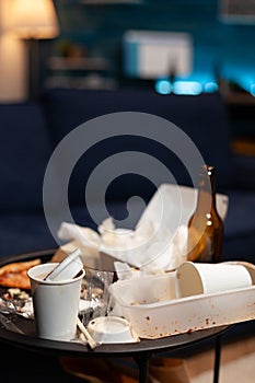 Chaotic home of lonely person with sever mental health problem having rubbish on messy table