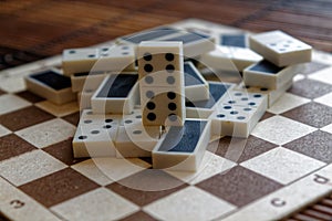 Chaotic pile of domino pieces on the bamboo brown wooden table background