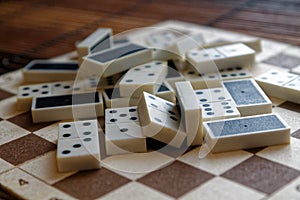 Chaotic pile of domino pieces on the bamboo brown wooden table background