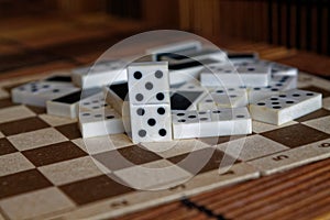 Chaotic pile of domino pieces on the bamboo brown wooden table background