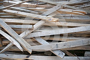 Chaotic pile of used wooden boards with nails.