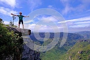 The cliffs of the Cachoeira Da Fumaca, Smoke Waterfall, with a hiker standing on the edge, Vale Do Capao, Bahia, Brazil photo