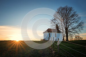 Chapel on the hill at sunset, with sun rays